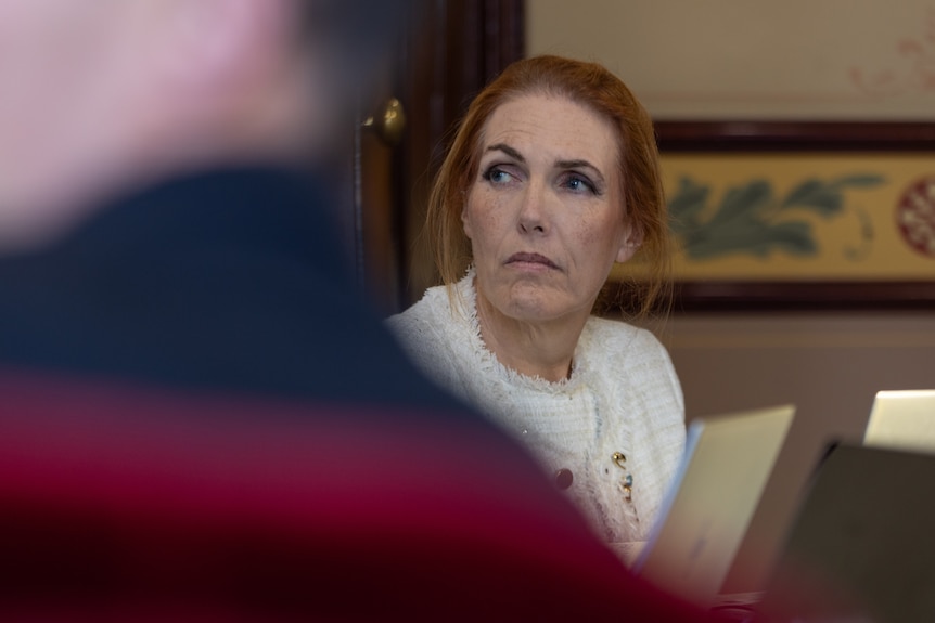 A woman in a white jacket.