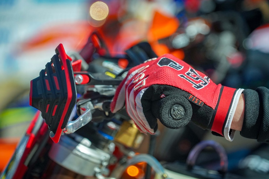 A motorcyclist has his gloved hands on the throttle