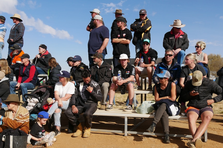 A crowd gathers to watch 4WDs race in the desert