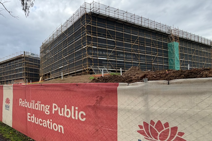 A multi-storey construction site with a sign saying