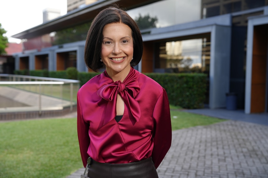 Prue Car wearing a red top.