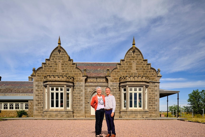 Jane and Neil stand out the front of their bluestone estate.