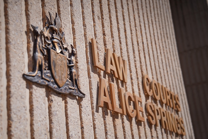 A close-up of a sign on the side of a building, it reads: Law Courts Alice Springs