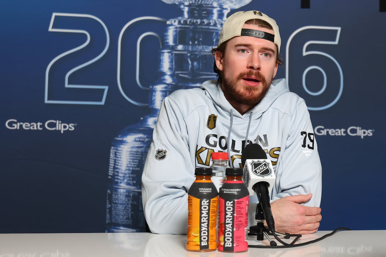 hockey player sits at a table and does interviews