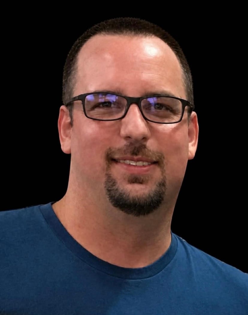 man wear blue shirt with black background.