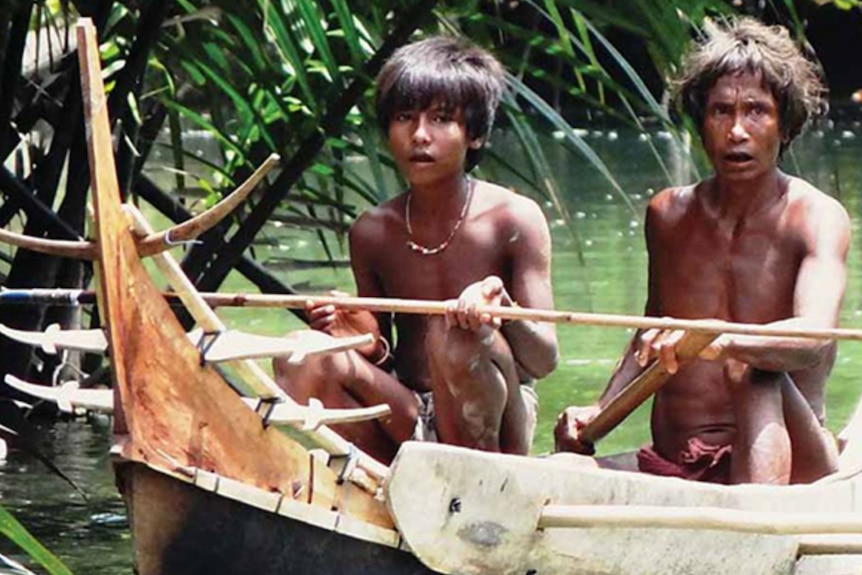 Shompen elder and child in canoe