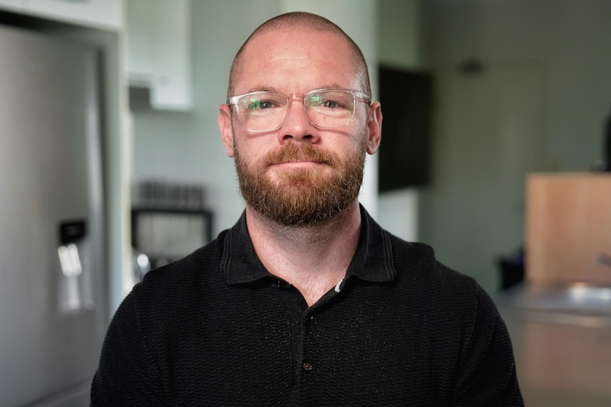 A white male with a beard standing in a kitchen