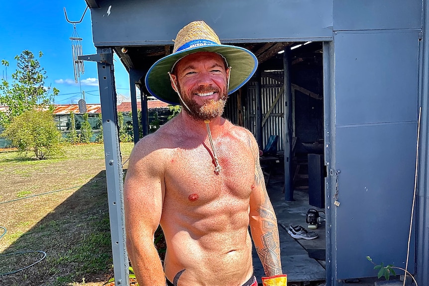 A young white man with muscles with his shirt off in the sun