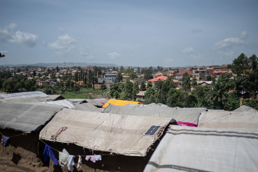 An aerial view of tent structures on a city horizon.
