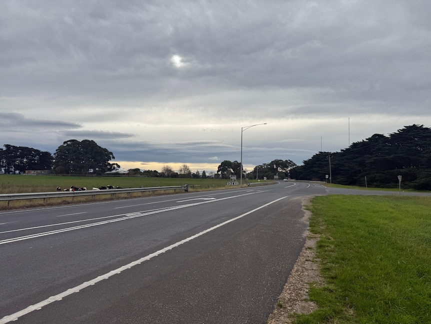 A photo of a cross-intersection road situated near farms in a regional area