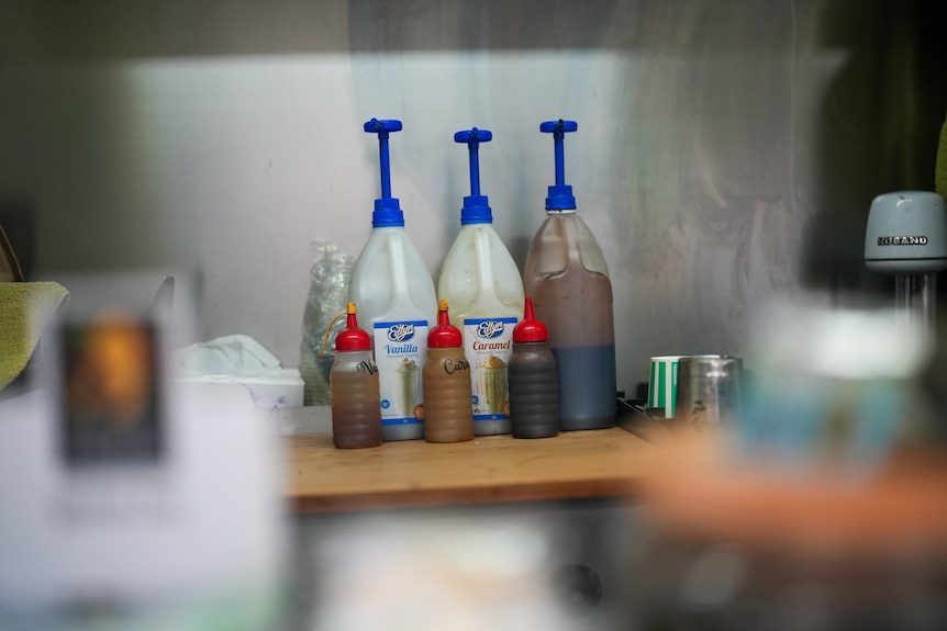 Vanilla and caramel pump bottles on industrial kitchen bench