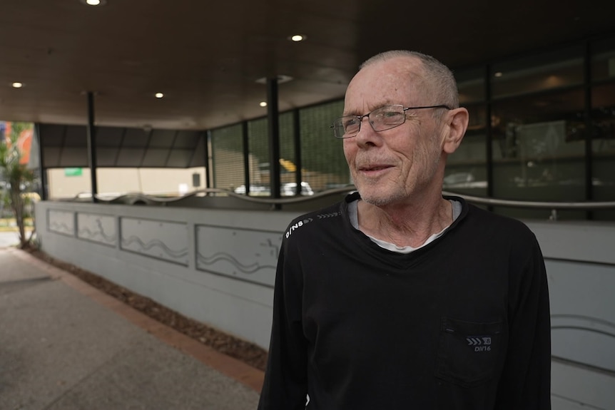 Resident Ian on a street in front of a business. 