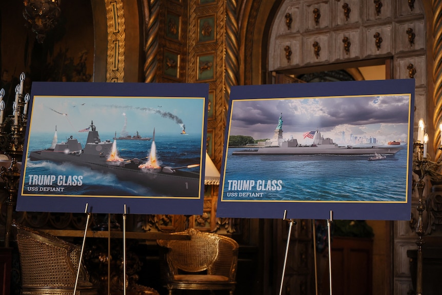 Images of Trump-class battleships, including explosions, are shown on poster boards on stands..